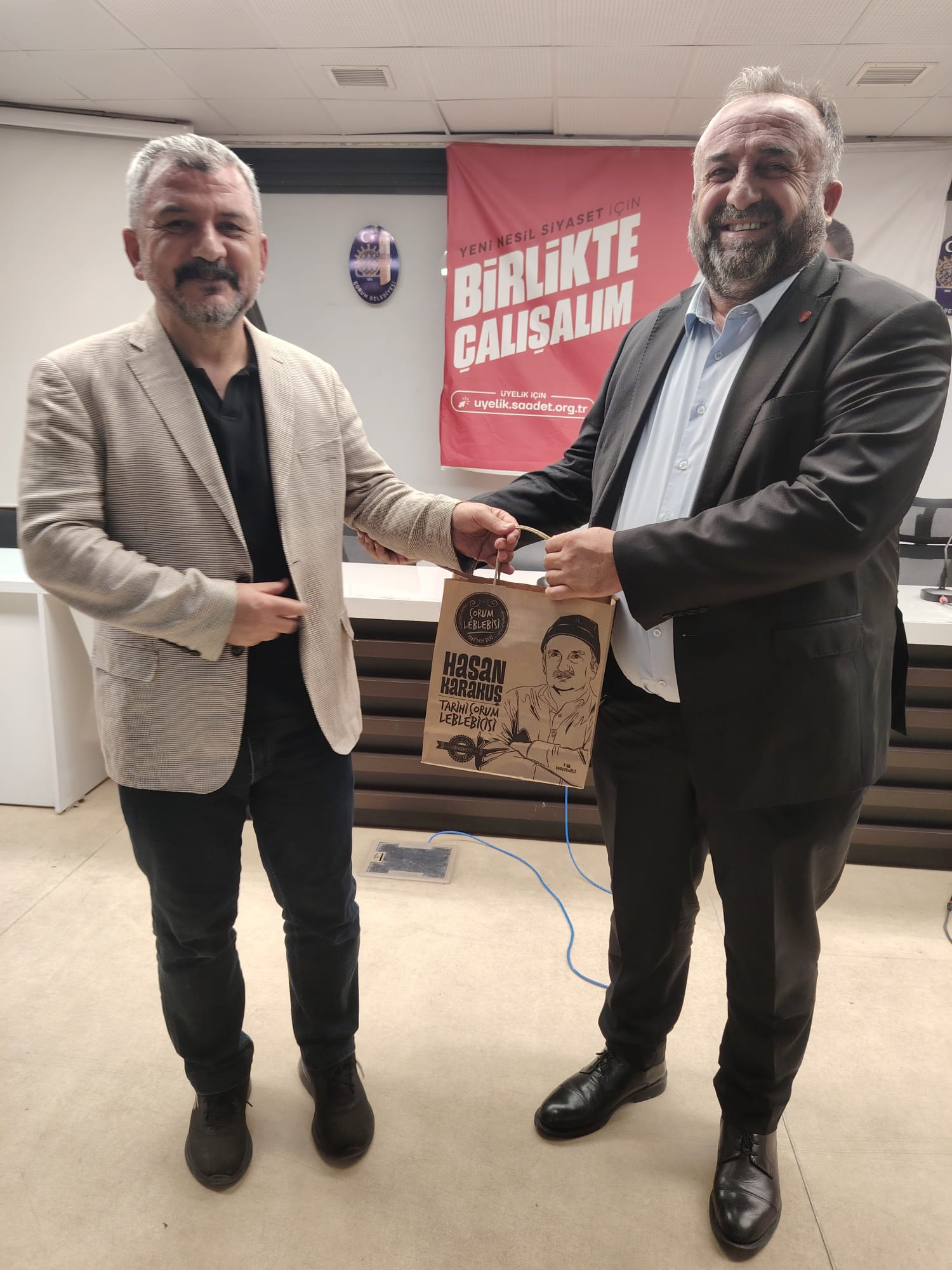 Saadet Partisi Çorum İl Başkanı Şuayip Sarı, günün anısına Yazar Muammer Bilgiç'e hediye takdim etti